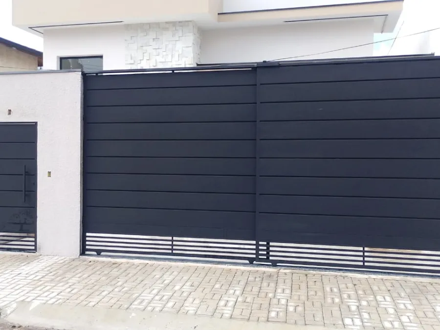 Portão de correr preto sob medida instalado em fachada residencial